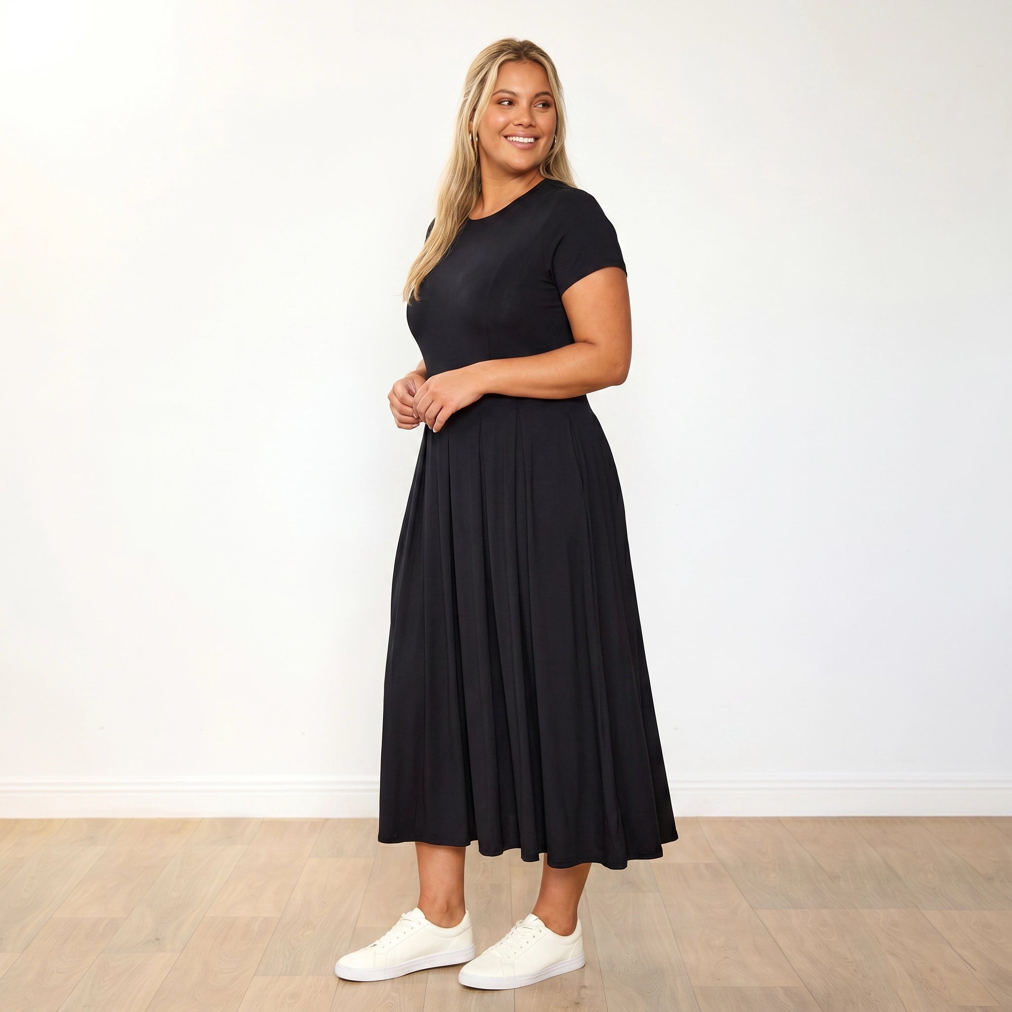 Polly Dress Black - Plus Size Model XXL, holding skirt showing pleats