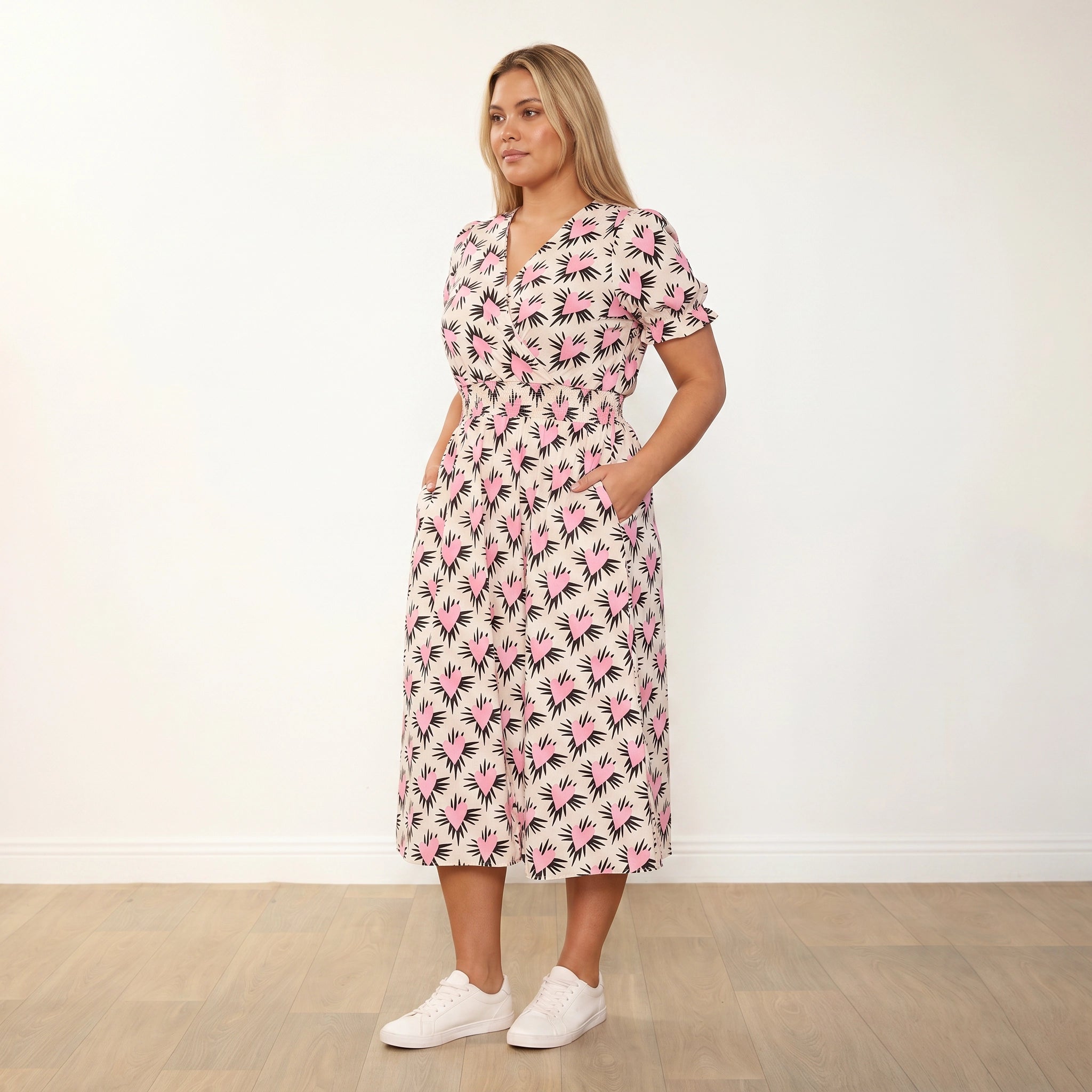 Belle Dress (Pink Heart) - Plus Size Model XXL, slight body turn hands in pockets looking off camera