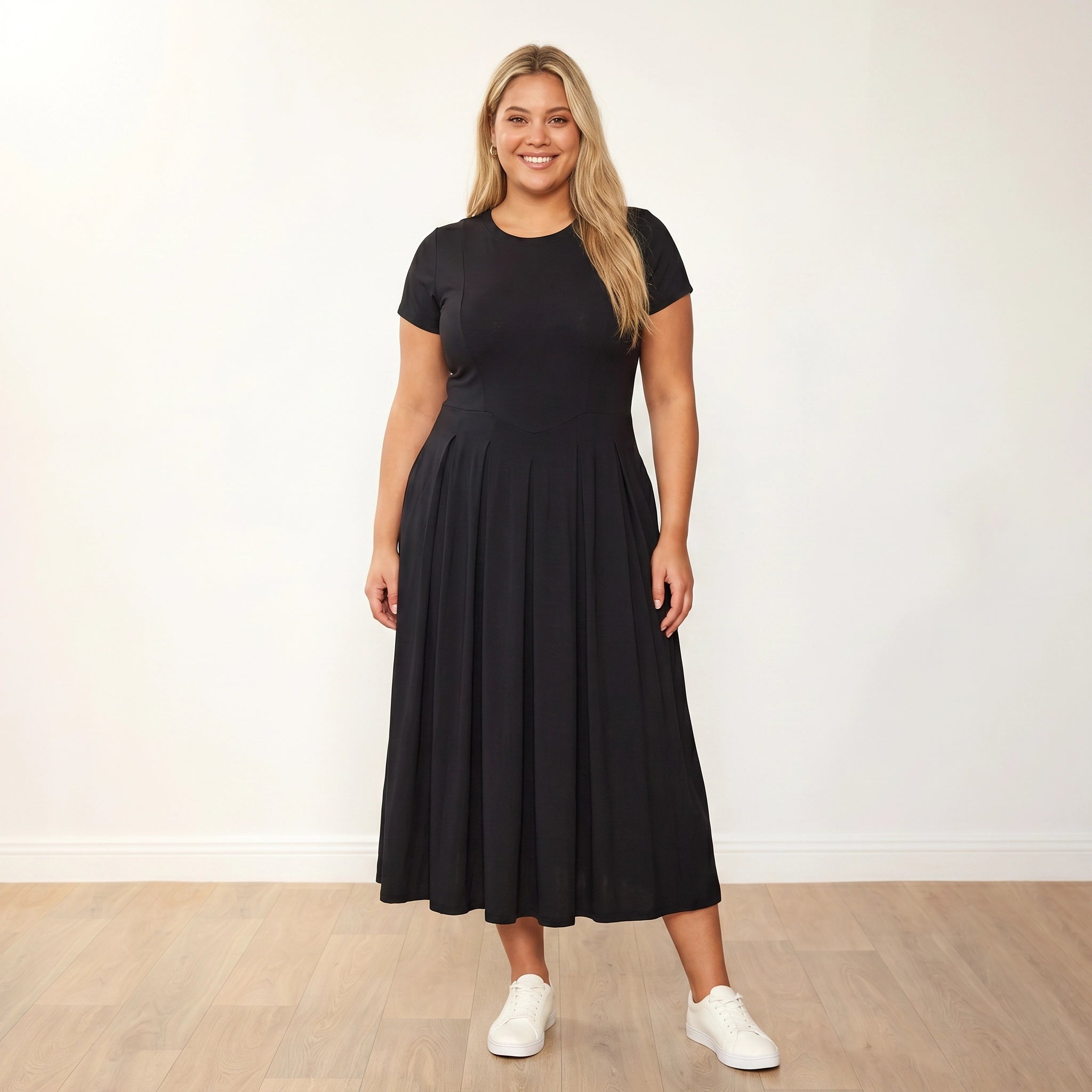 Polly Dress Black - Plus Size Model XXL, front hands in pockets warm smile