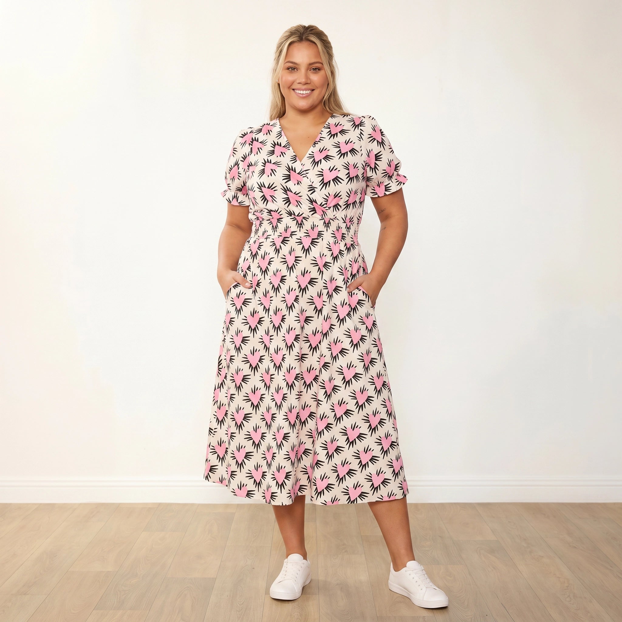 Belle Dress (Pink Heart) - Plus Size Model XXL, front facing hands in pockets warm smile