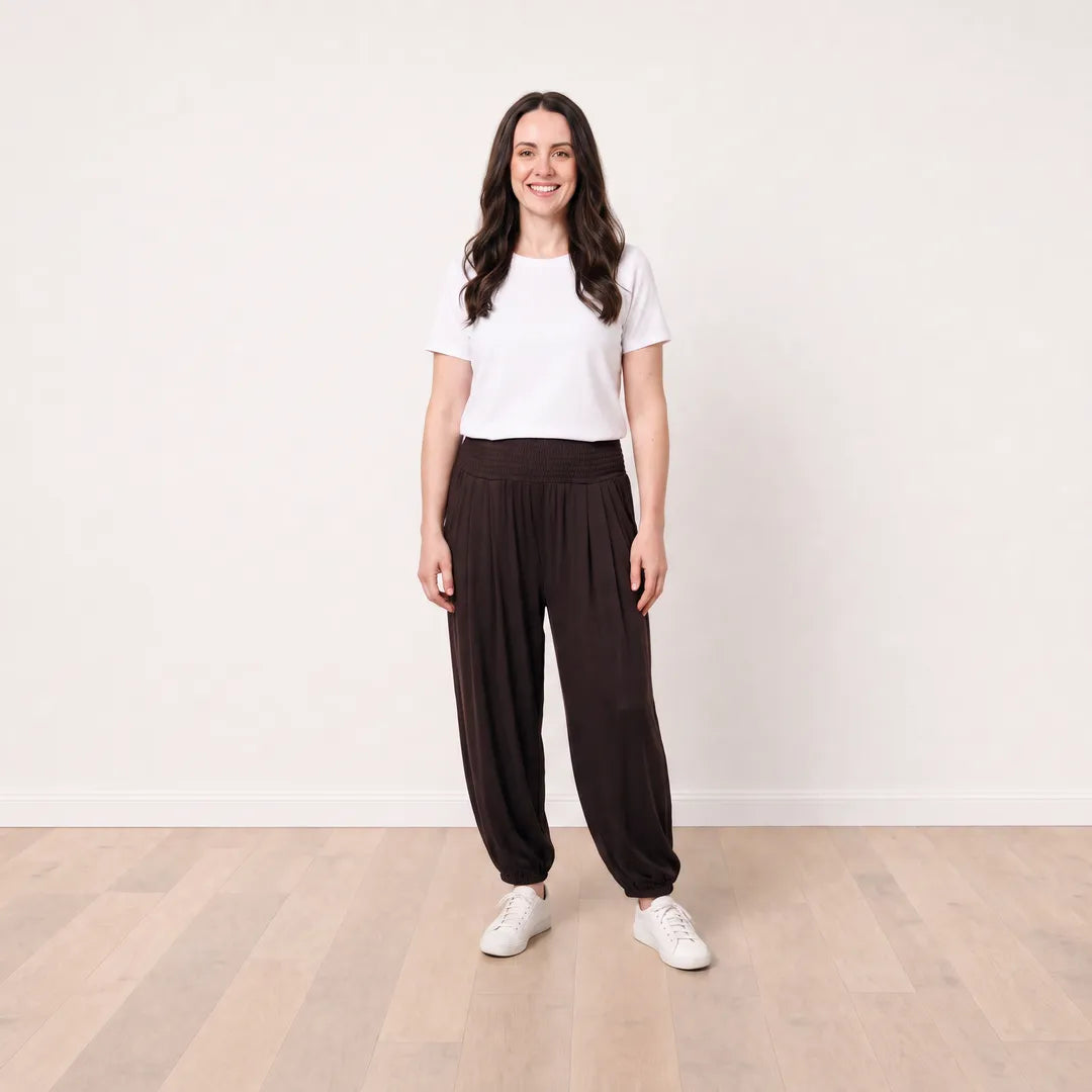 T_Róisín wearing Orla Trousers in Chocolate Brown with a white top, front view