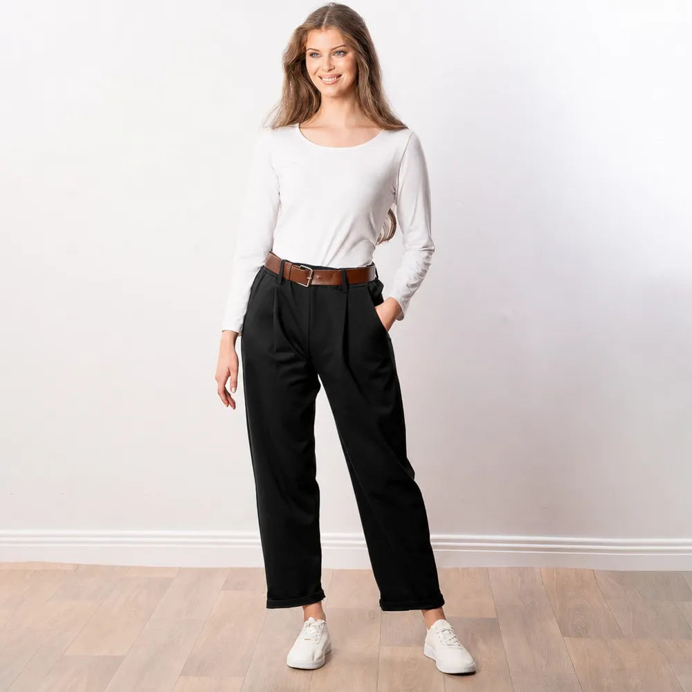 Smiling woman in black Arya tapered trousers with pleated front, white top and tan leather belt