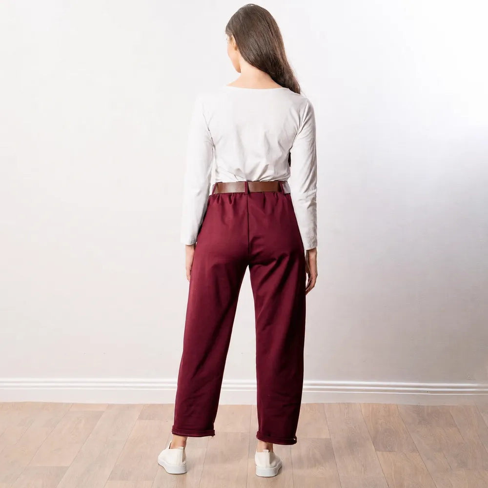 Arya Tapered Trousers in wine — full back view with white trainers and pale oak studio floor