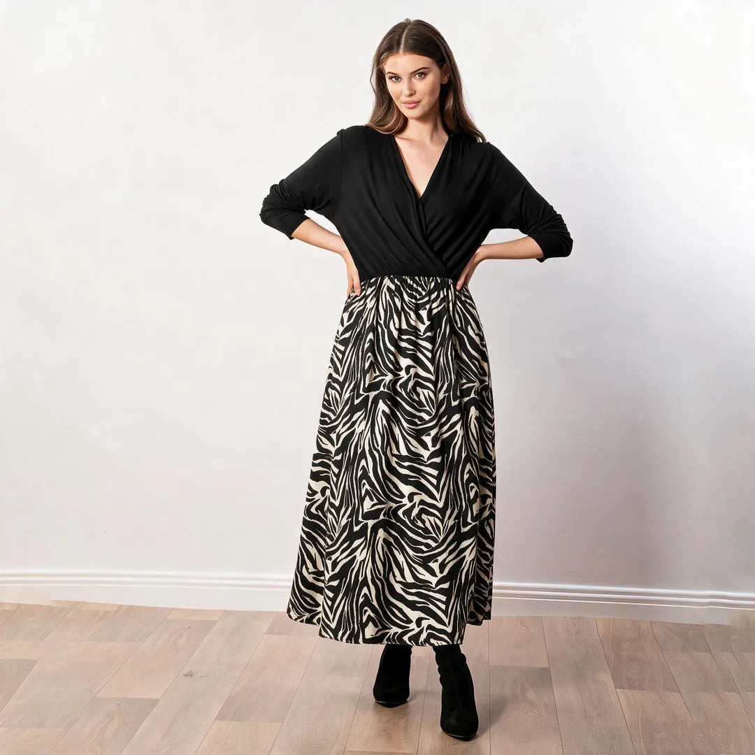 Audrey Dress in black and cream zebra print, front view with black wrap bodice, hands on hips