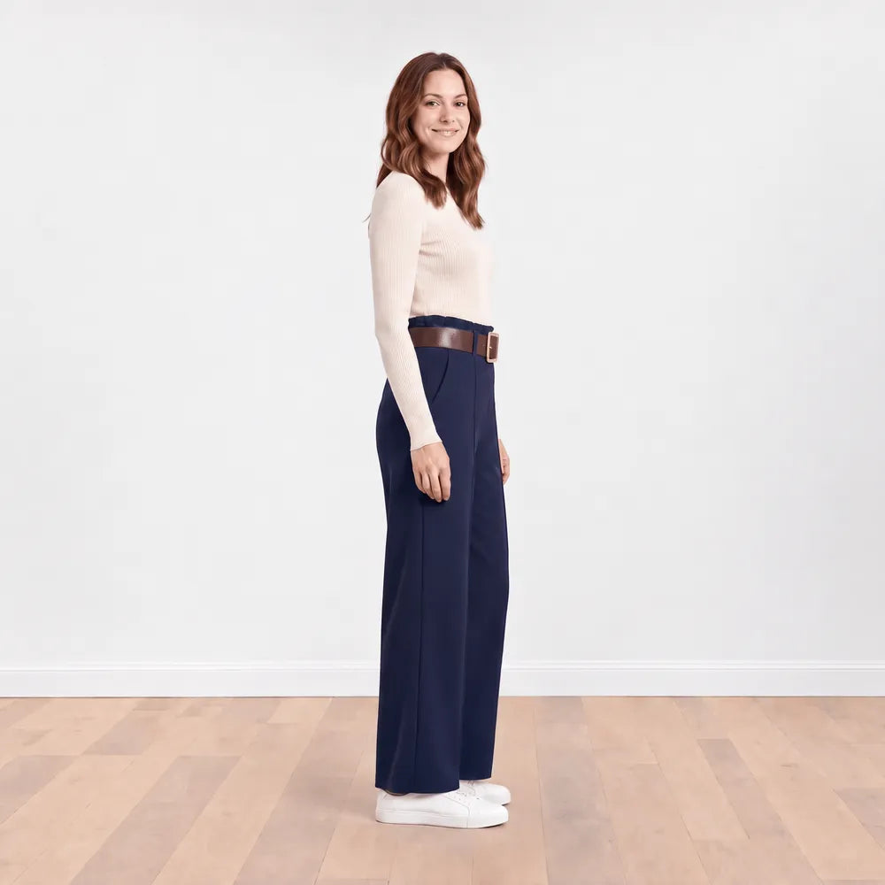 Side profile view of navy Ellana wide-leg paperbag-waist trousers with brown leather belt and cream ribbed knit top