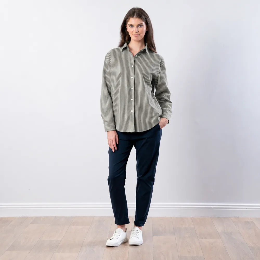 Woman wearing the Fallon Stripe Shirt in green with white pinstripes, styled with navy trousers and white trainers, full front view