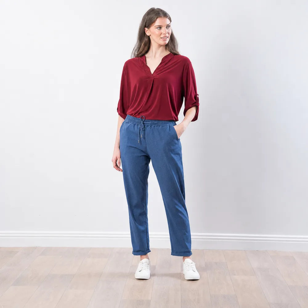 The Casual Company Stella Jogger in denim blue, front angled view with hand in pocket
