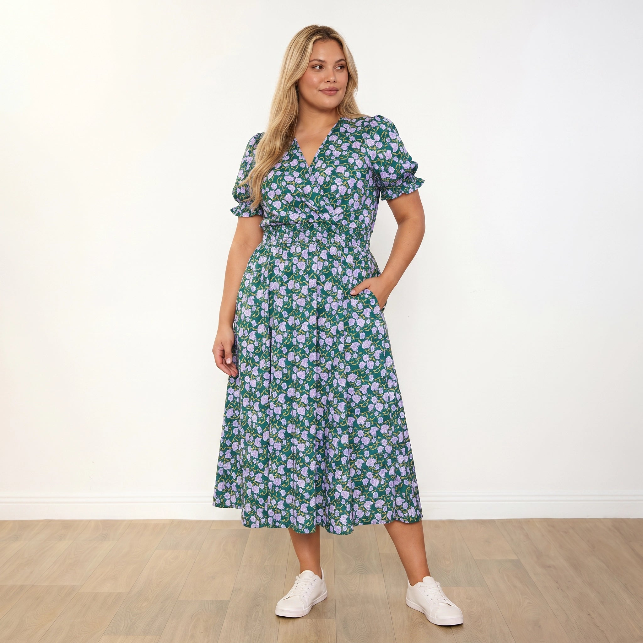 Belle Dress Green Lilac Wildflower - plus size model front, one hand in pocket, looking right