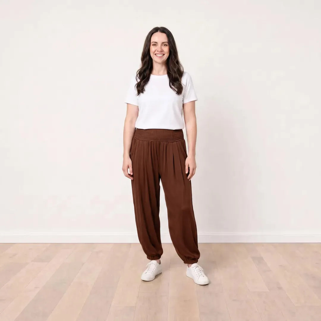 T_Róisín wearing Orla Trousers in Chocolate Brown with a white top, front view